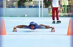 A skater stretching low on the rink